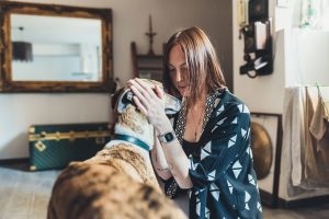 Jonge vrouw die haar hond in appartement aait