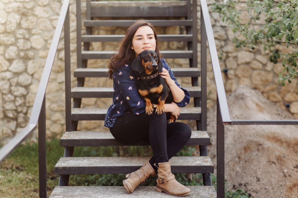 jovem em uma caminhada com seu dachshund